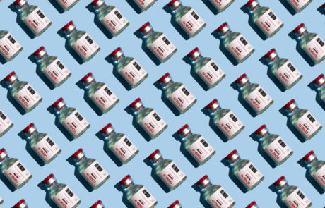 Repeated vials with covid-19 vaccine on the blue background