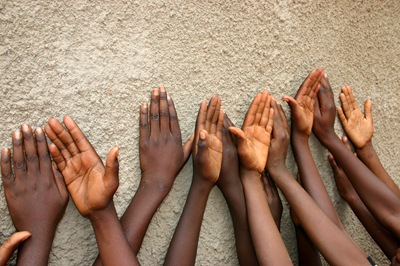 Integrating health services for HIV infection, diabetes and hypertension in sub-Saharan Africa Children’s hands raised against a textured wall.